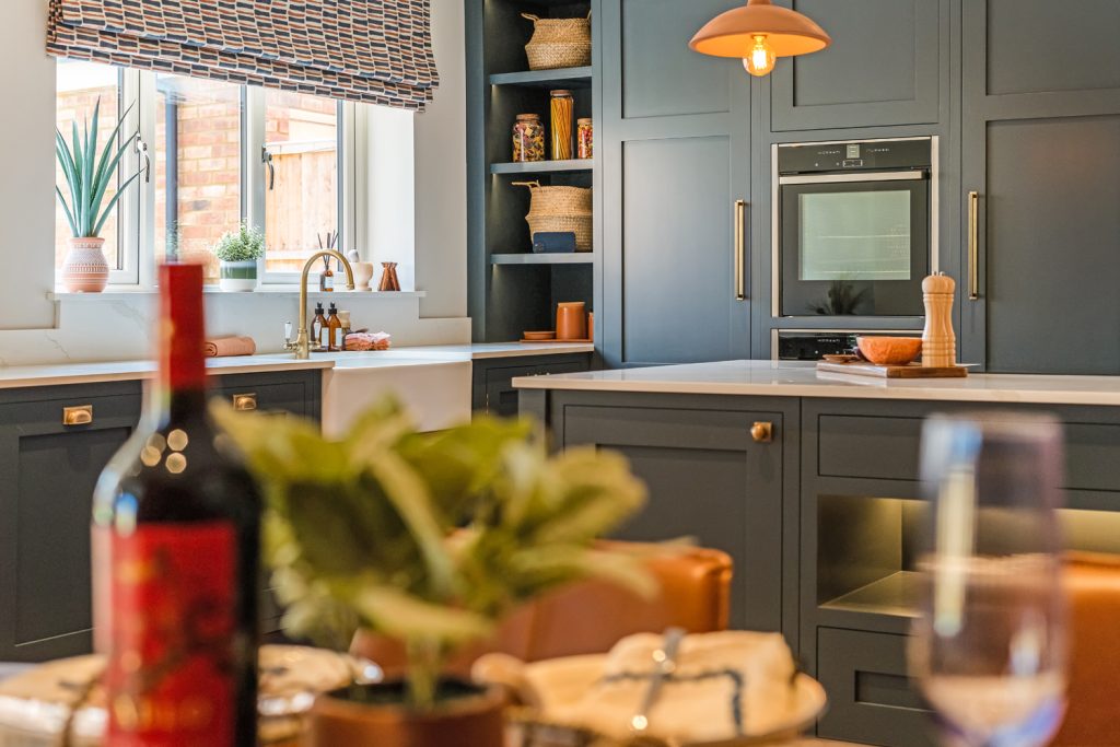 Detail image of modern grey kitchen with wine bottle in foreground